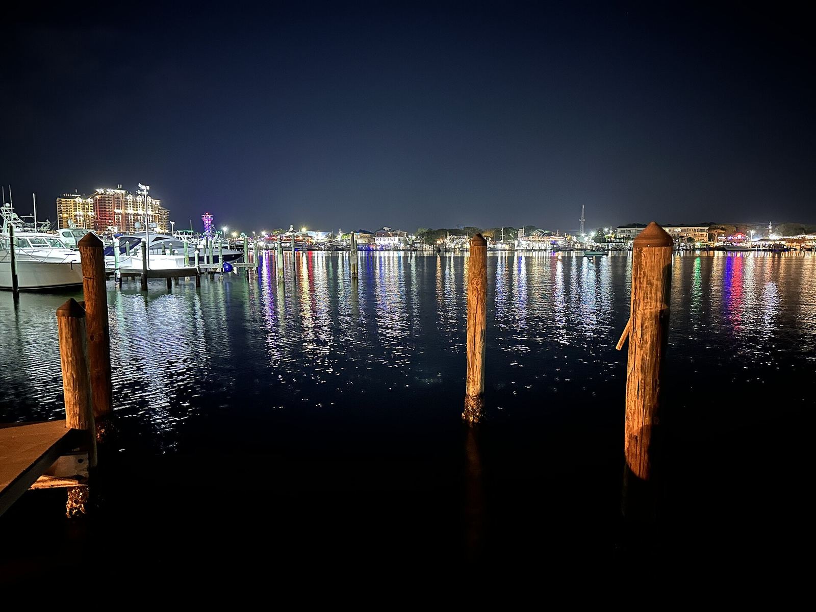 Destin Harbor lit up at night with boats and waterfront buildings